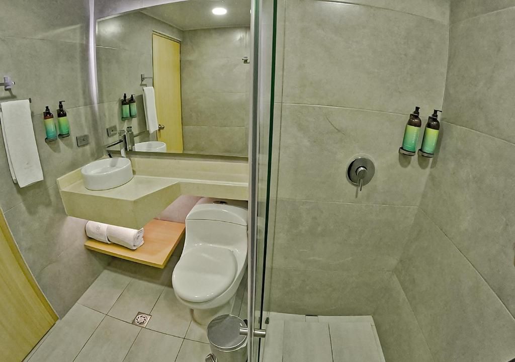 A modern bathroom with a glass-enclosed shower, a sink, and a toilet.