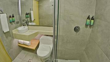 A modern bathroom with a glass-enclosed shower, a sink, and a toilet.