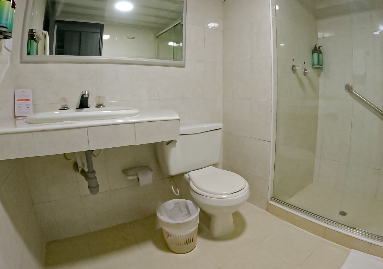 A bathroom with a toilet, sink, and shower.