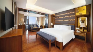 A modern hotel room with a large bed, a desk, a flat-screen TV, and a balcony with a city view. - Sanya Yi Yuan Xuan Yu Hotel (Sanya)