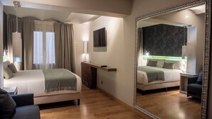 A hotel room with two beds, a large mirror, a desk, and a chair. - Vasanta Hotel (Barcelona)