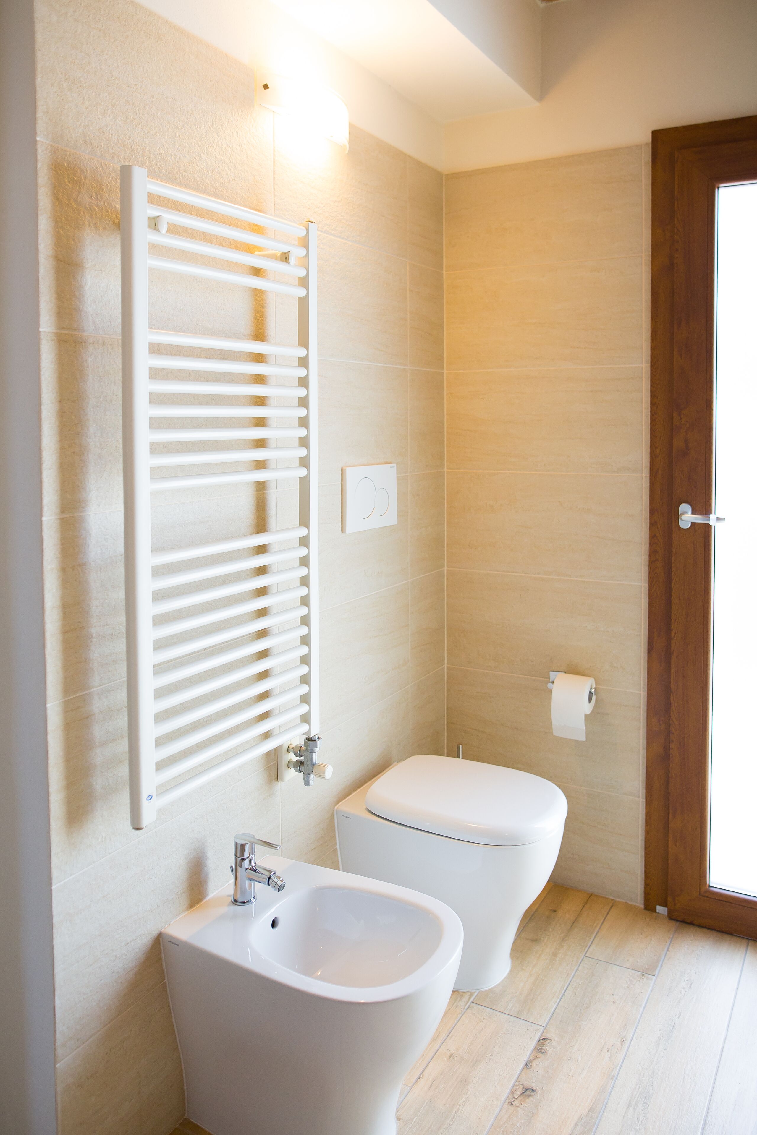 A bathroom with a white bathtub, a white toilet, and a towel rack.