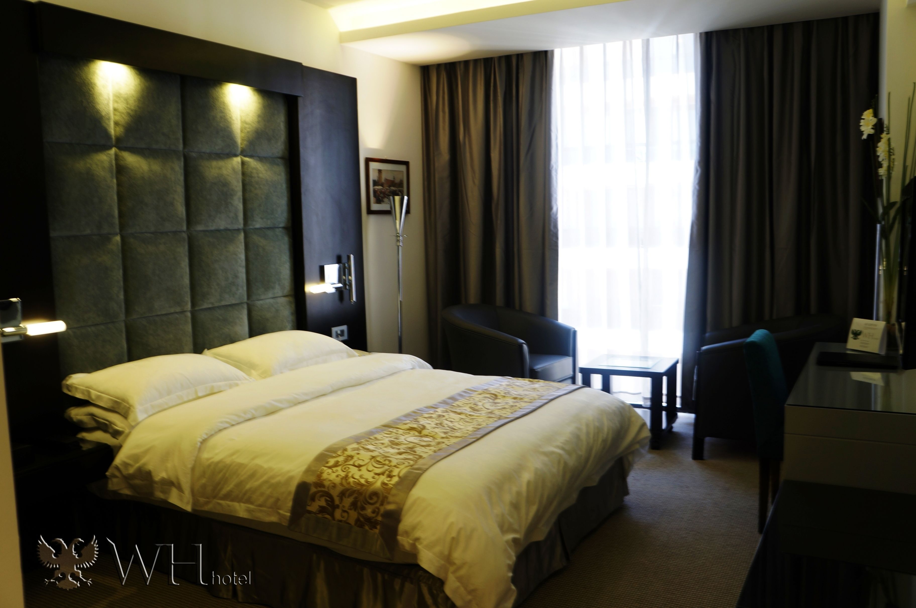 Una habitación de hotel con una cama grande, un escritorio y una silla.