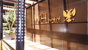A WH hotel sign with a golden eagle emblem. - WH Hotel (Beirut)