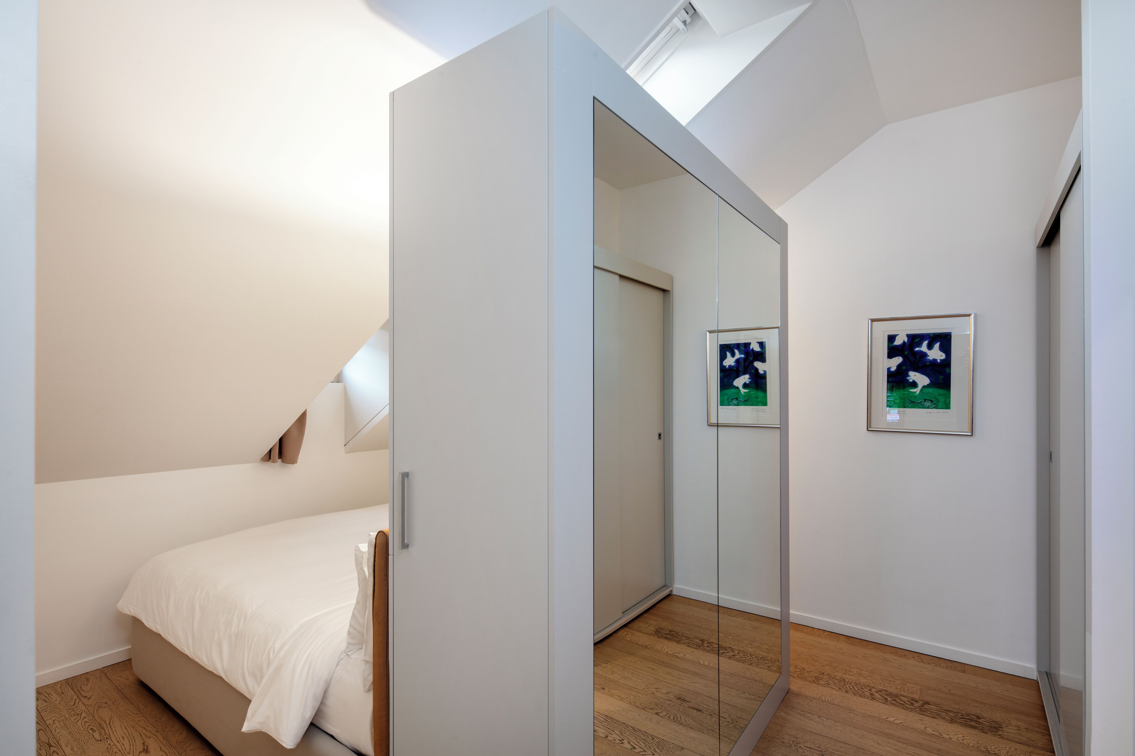 Une chambre à coucher avec un lit, une armoire et un miroir.