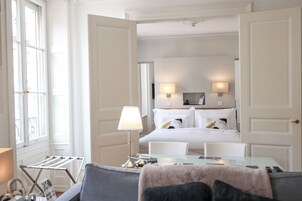 Una habitación de hotel con cama, lámparas de noche, escritorio y una silla.
