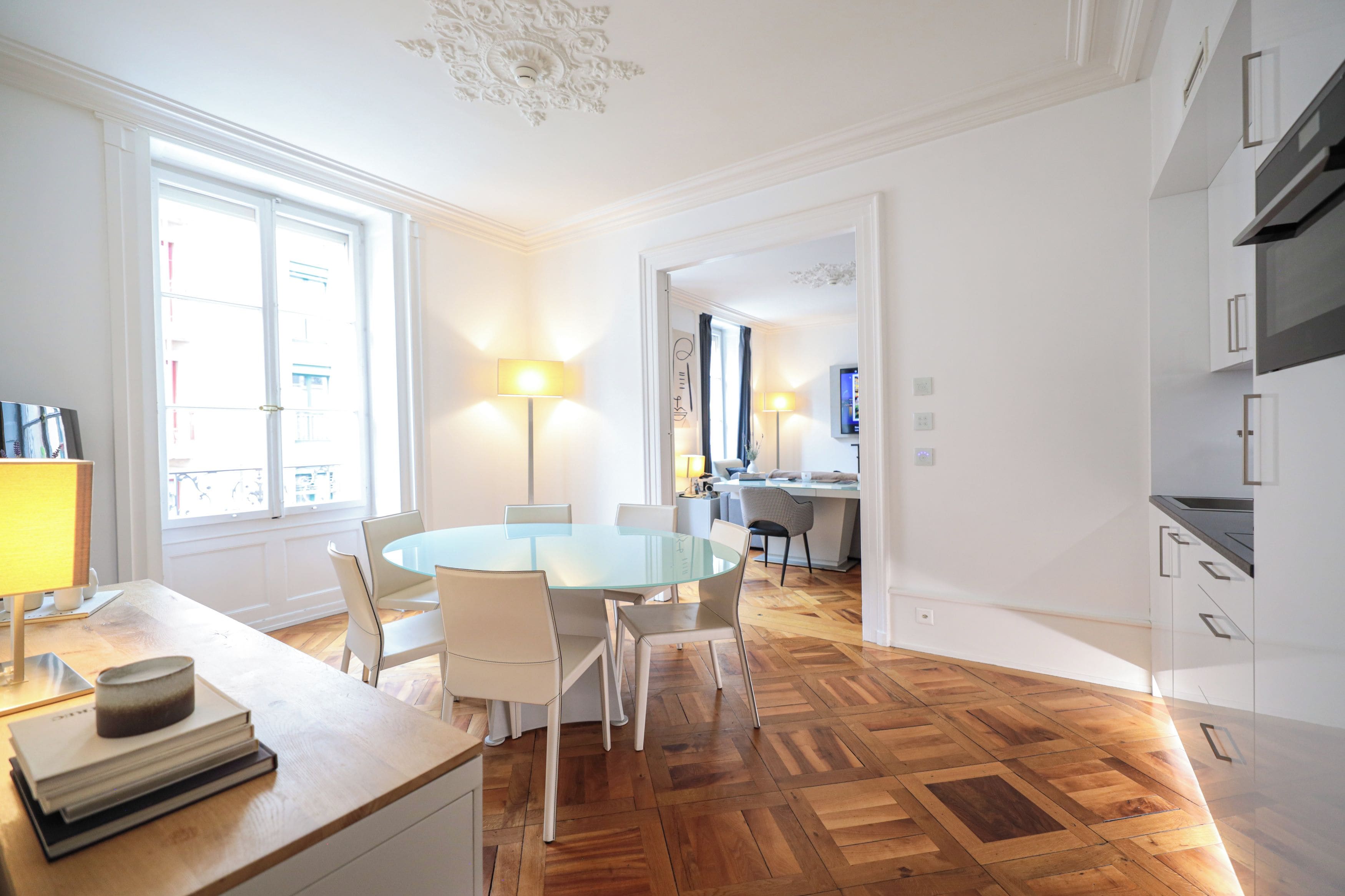 Una cocina moderna con comedor, suelo de madera y vistas a la ciudad.