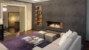 A modern living room with a fireplace, a sofa, and a coffee table with magazines. - Swiss Luxury Apartments Geneva (Geneva)