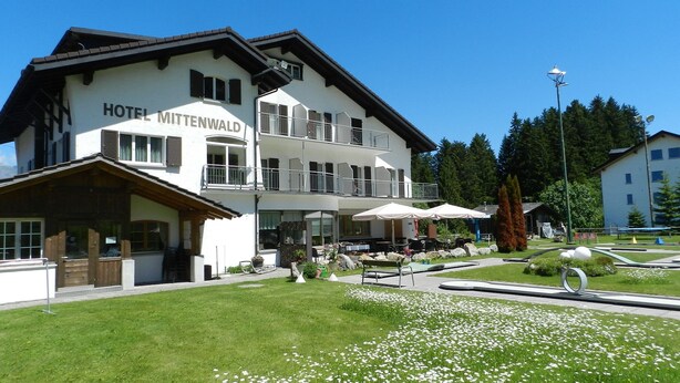 A two-story hotel with a balcony and outdoor seating area. - Hotel GARNI Mittenwald (Flums)