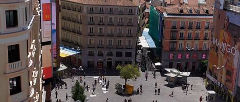 A spacious public square with historical buildings, a clock tower, and a large open area for gatherings.