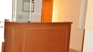 Un mostrador de recepción de madera con una puerta al fondo.
