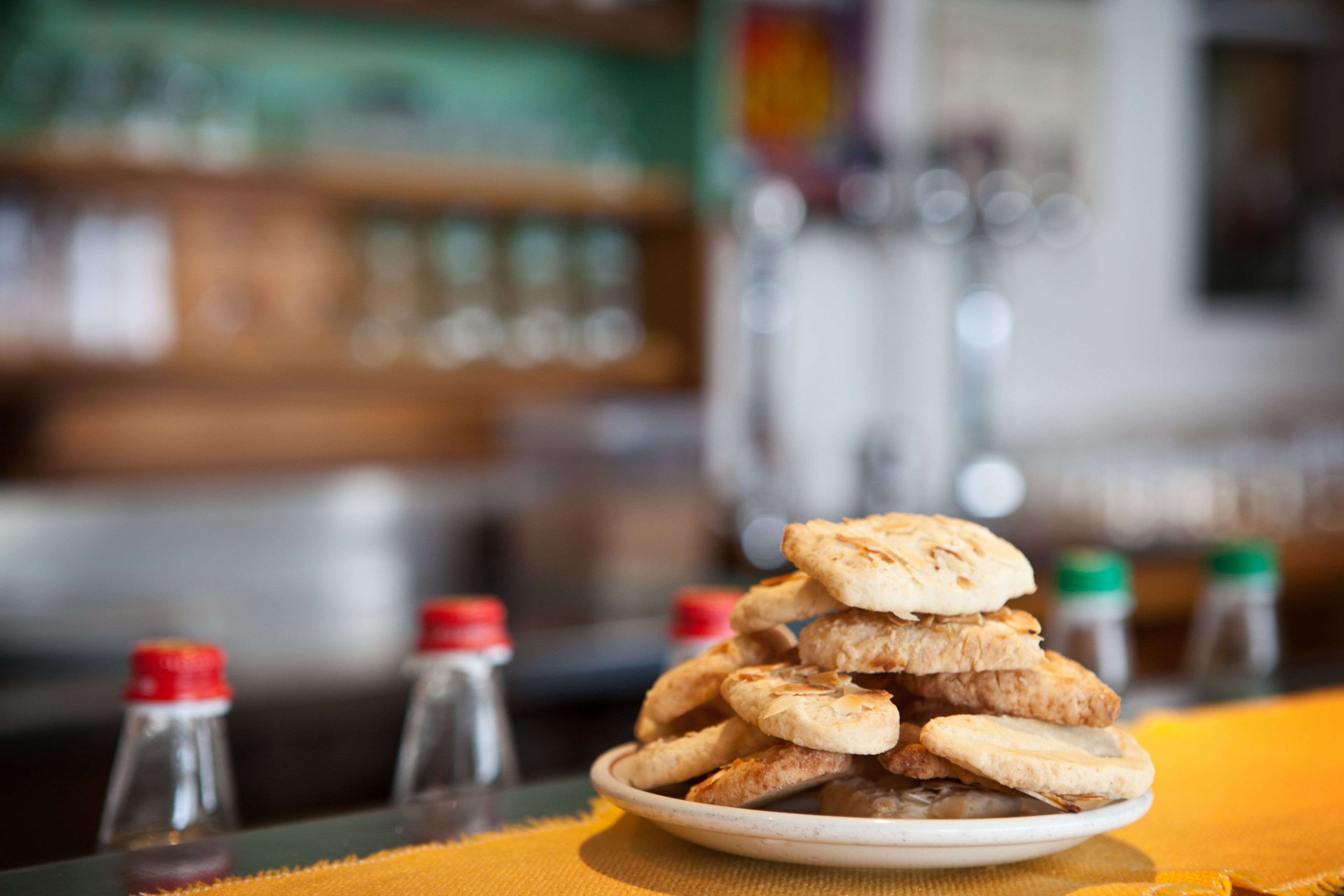 A plate of flatbreads stacked on a table with a yellow tablecloth.