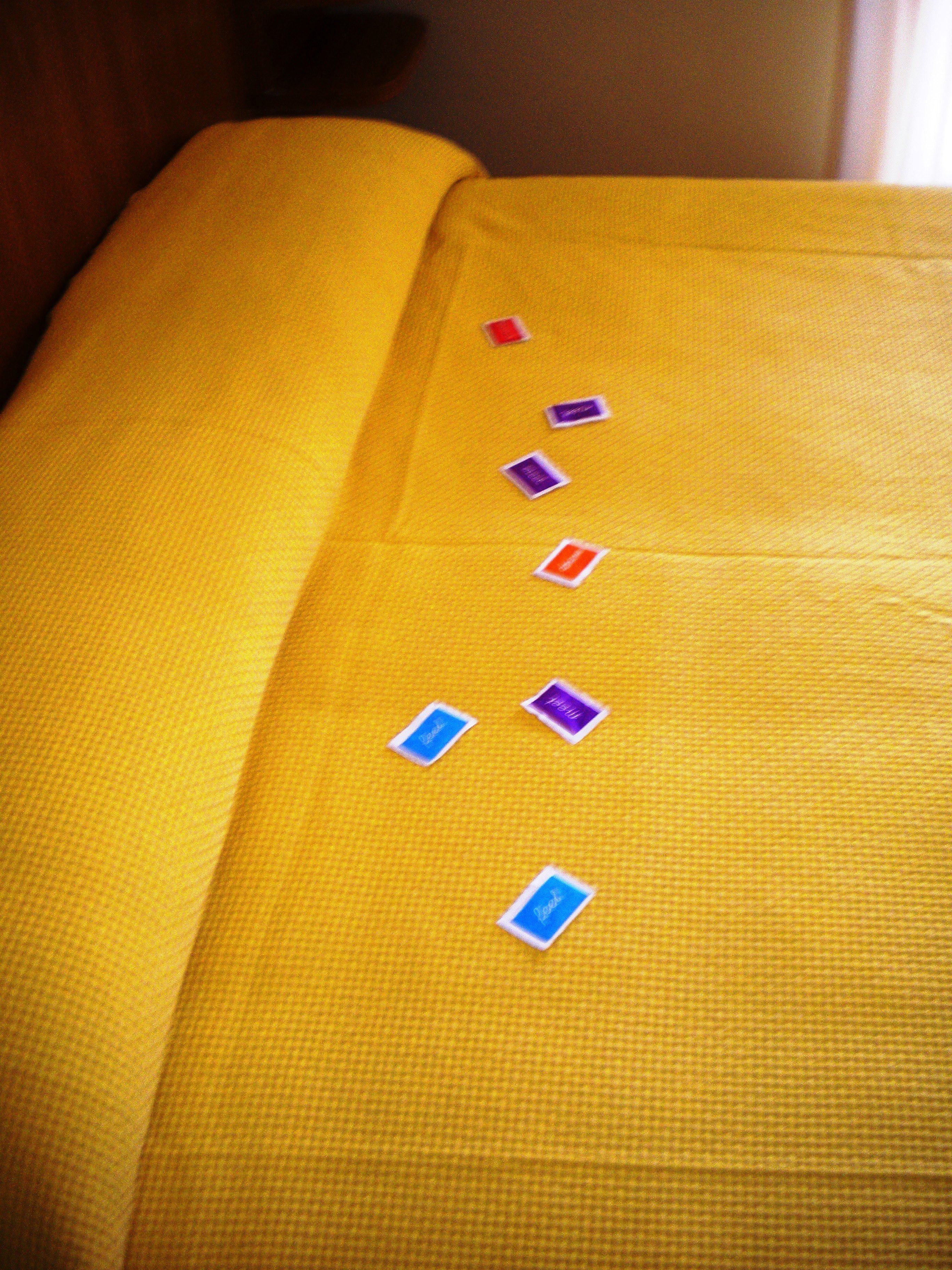 Tela amarilla con etiquetas rectangulares, de diferentes colores.