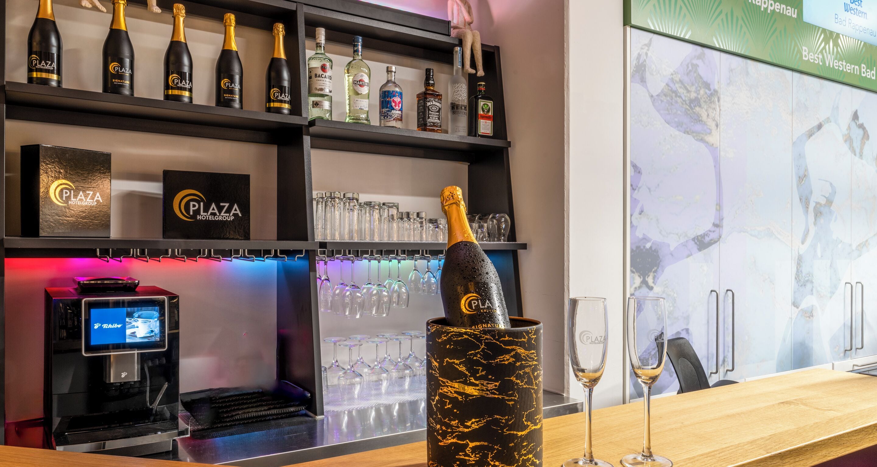 A bar area with a selection of liquor bottles, a champagne bottle in a decorative holder, and a digital payment terminal.
