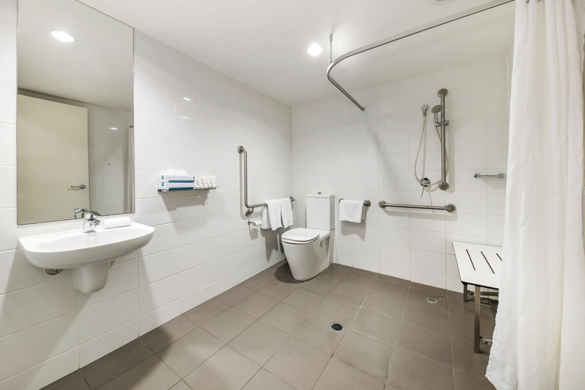A modern bathroom with a sink, toilet, and shower.