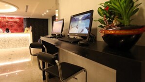 A reception desk with two monitors, a potted plant, and a black chair. - Ximen Citizen Hotel (Taipei)
