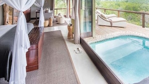 A luxurious bedroom with a large window, a private balcony, and a swimming pool. - Leopard Hills (Bushbuckridge)