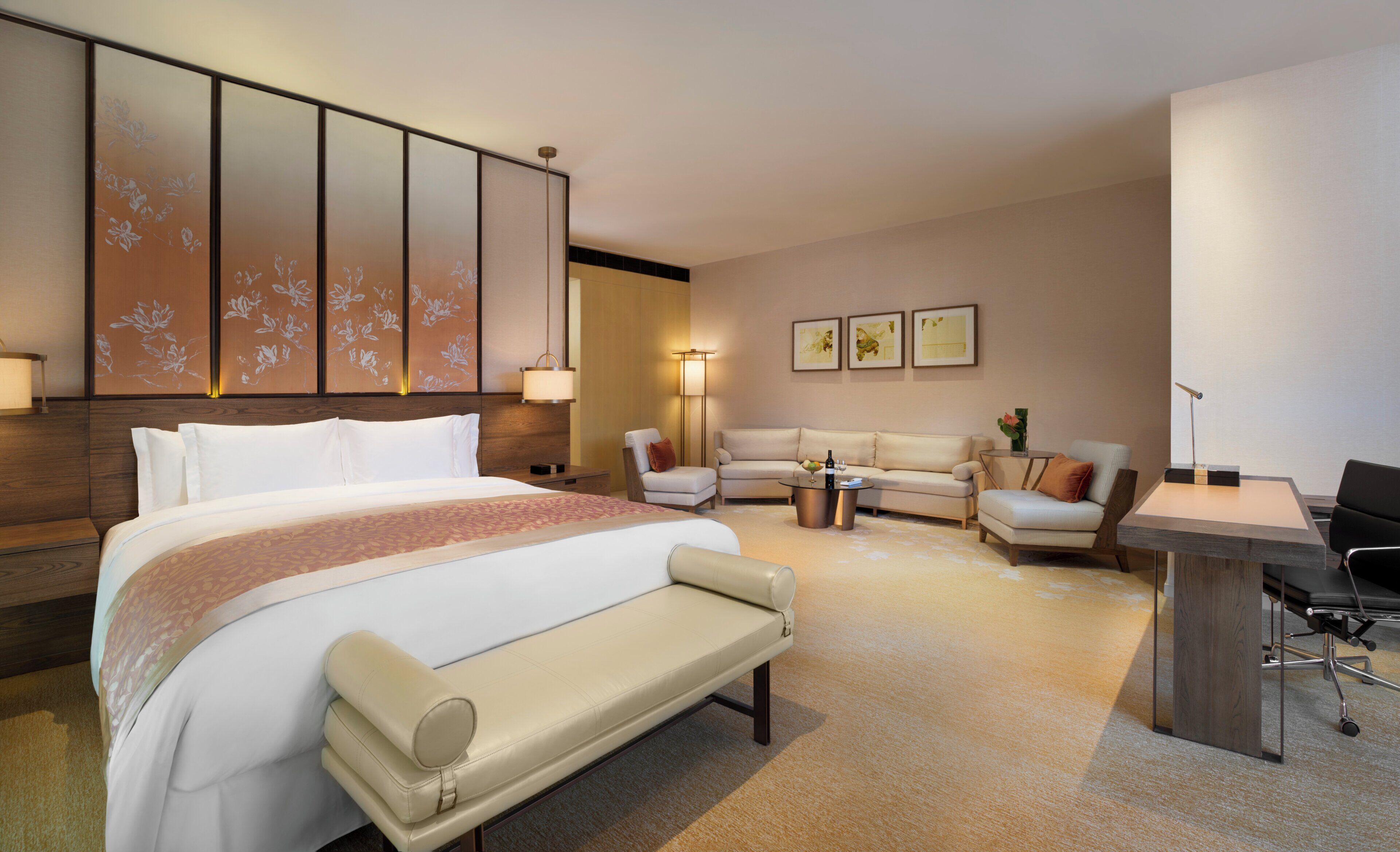 Habitación de hotel con una cama grande, un sofá, un escritorio y una silla.