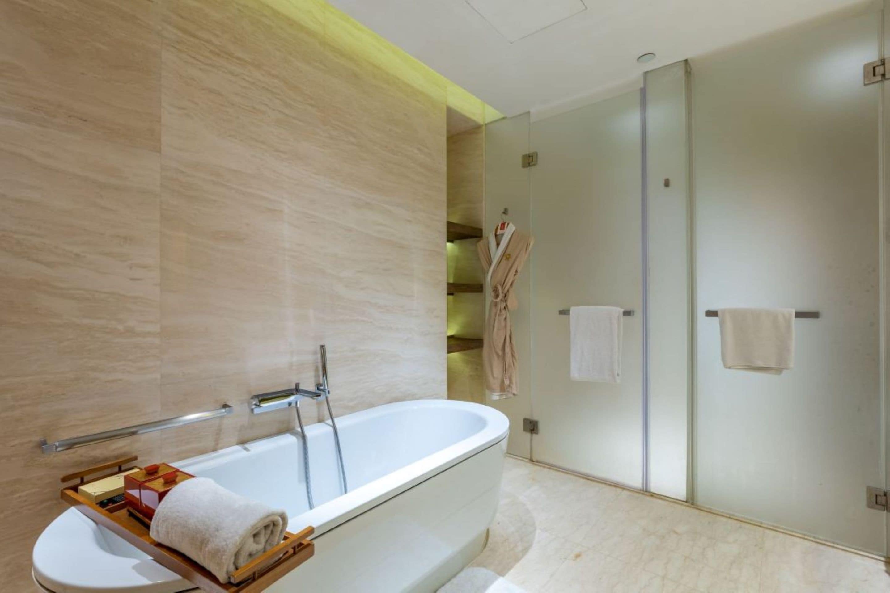 A modern bathroom with a freestanding bathtub, a glass shower enclosure, and a towel rack.