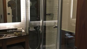 Une salle de bain moderne avec une douche à parois de verre, un meuble-lavabo avec un miroir et un porte-serviettes.
