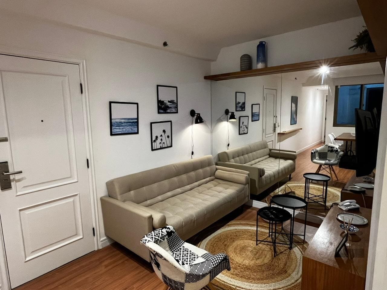 A living room with a sofa, chairs, a coffee table, and a TV.