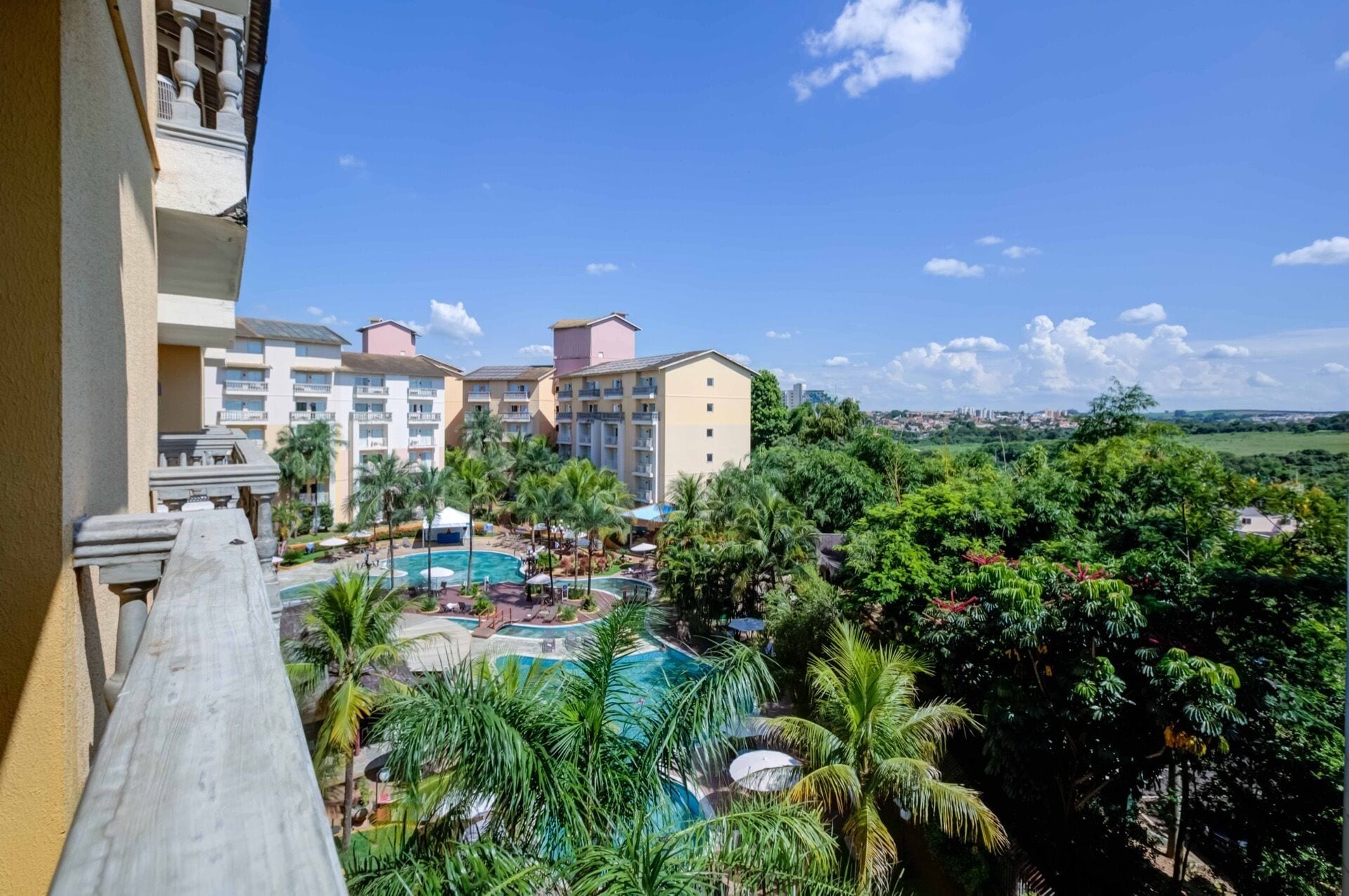 A resort with multiple buildings, a swimming pool area, and lush greenery.