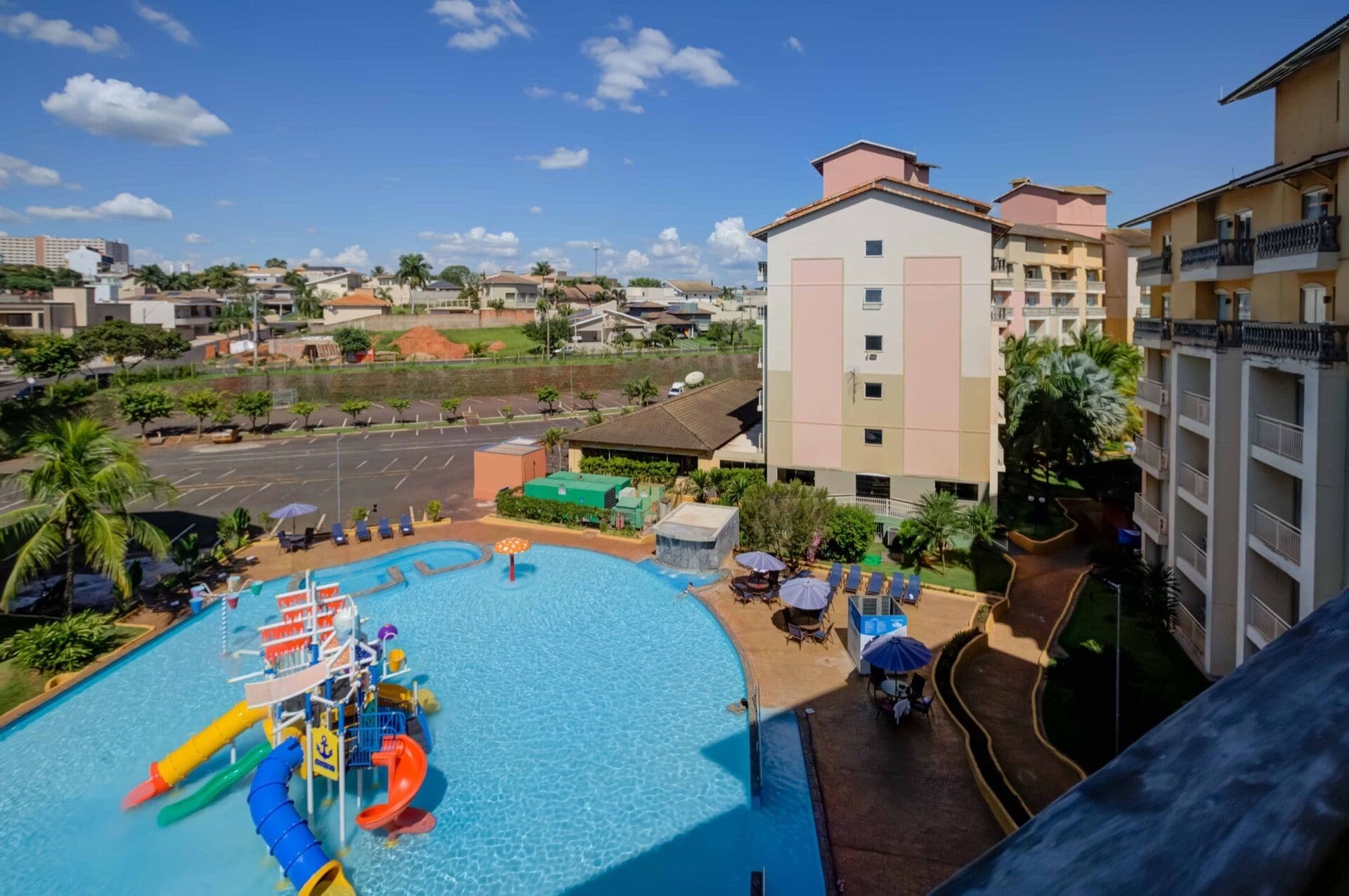 Un hotel con piscina, toboganes acuáticos y vistas del barrio circundante.