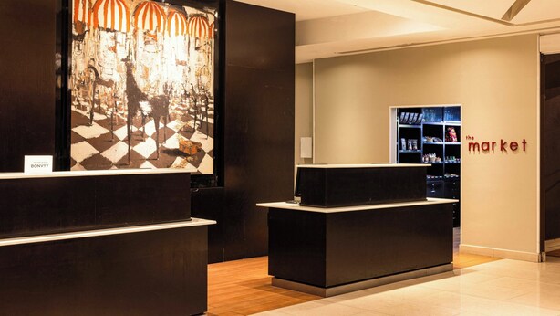 A reception area with a modern design, featuring a reception desk and a wall with a large abstract artwork. - Courtyard Toluca Tollocan (Toluca)