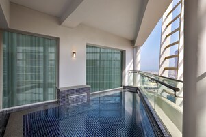 Una piscina interior moderna con paredes de vidrio y vistas a la ciudad.