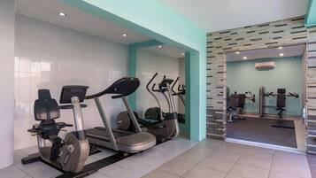 Un gimnasio con bicicletas estáticas, cintas de correr y máquinas de pesas.