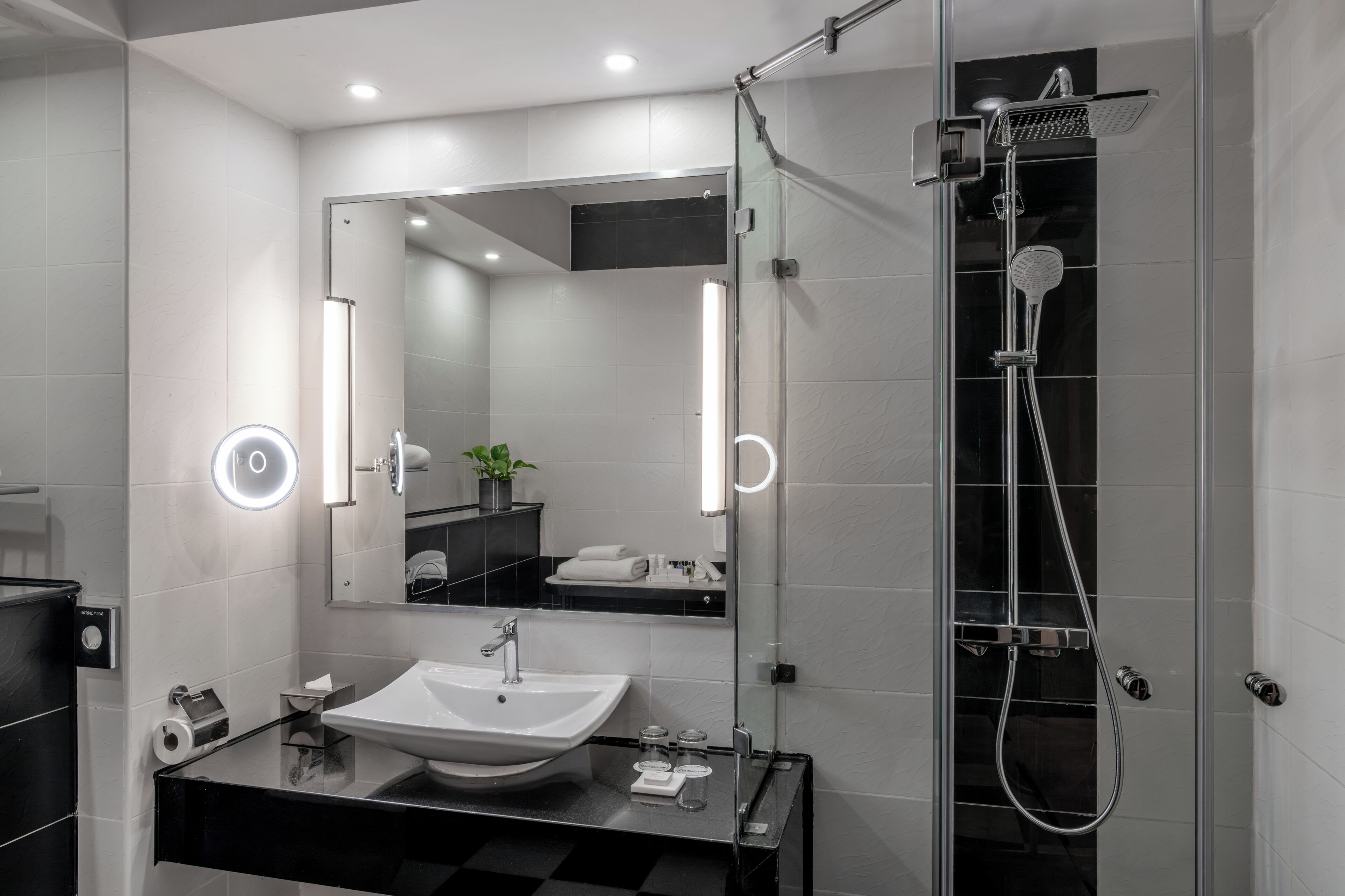 A modern bathroom with a sink, mirror, and shower.