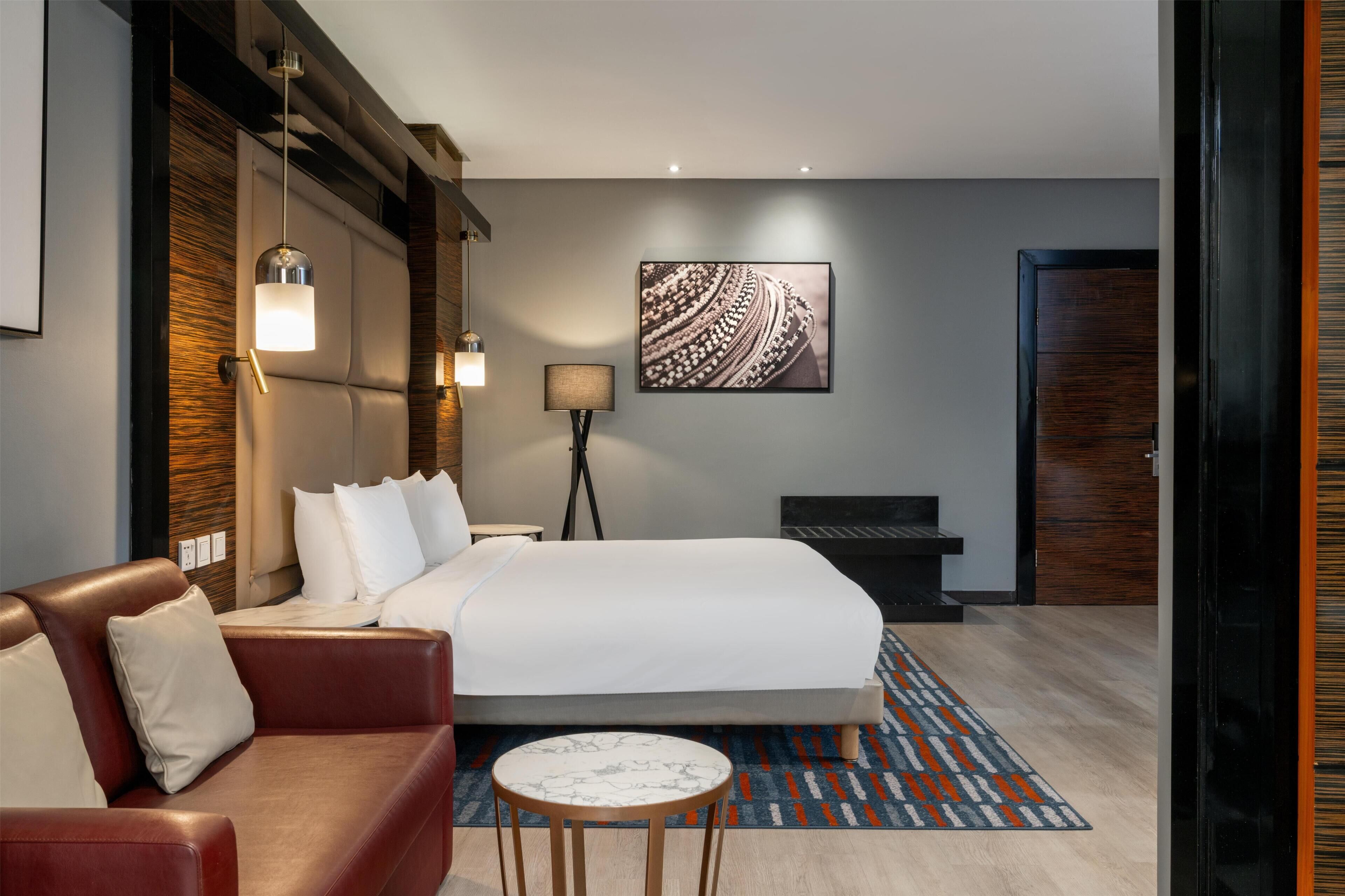 أغطية فراش متميزة وميني بار وخزنة داخل الغرفة ومكتب