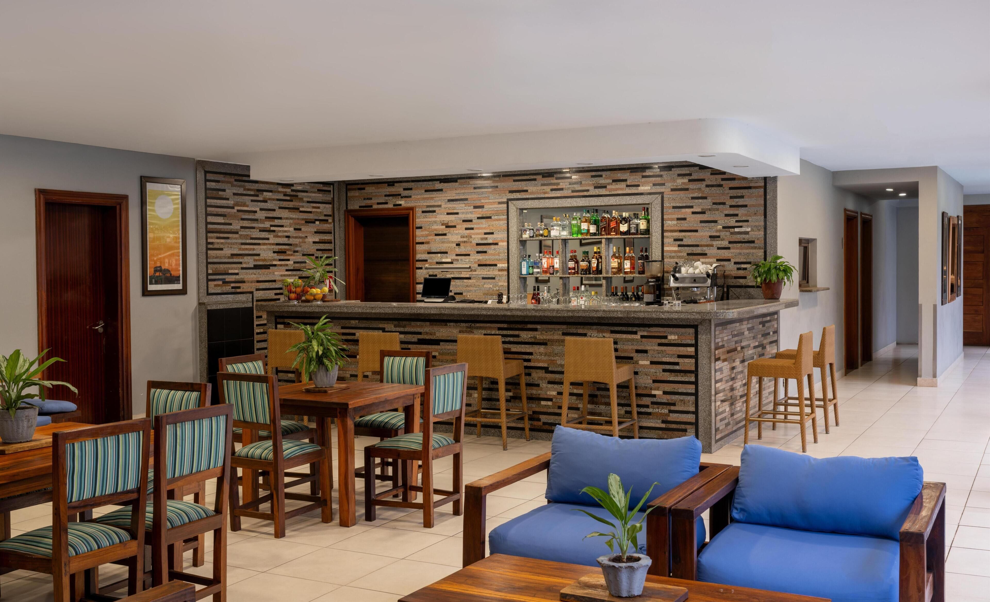 Una cocina moderna con barra, muebles de madera y suelo de baldosas.