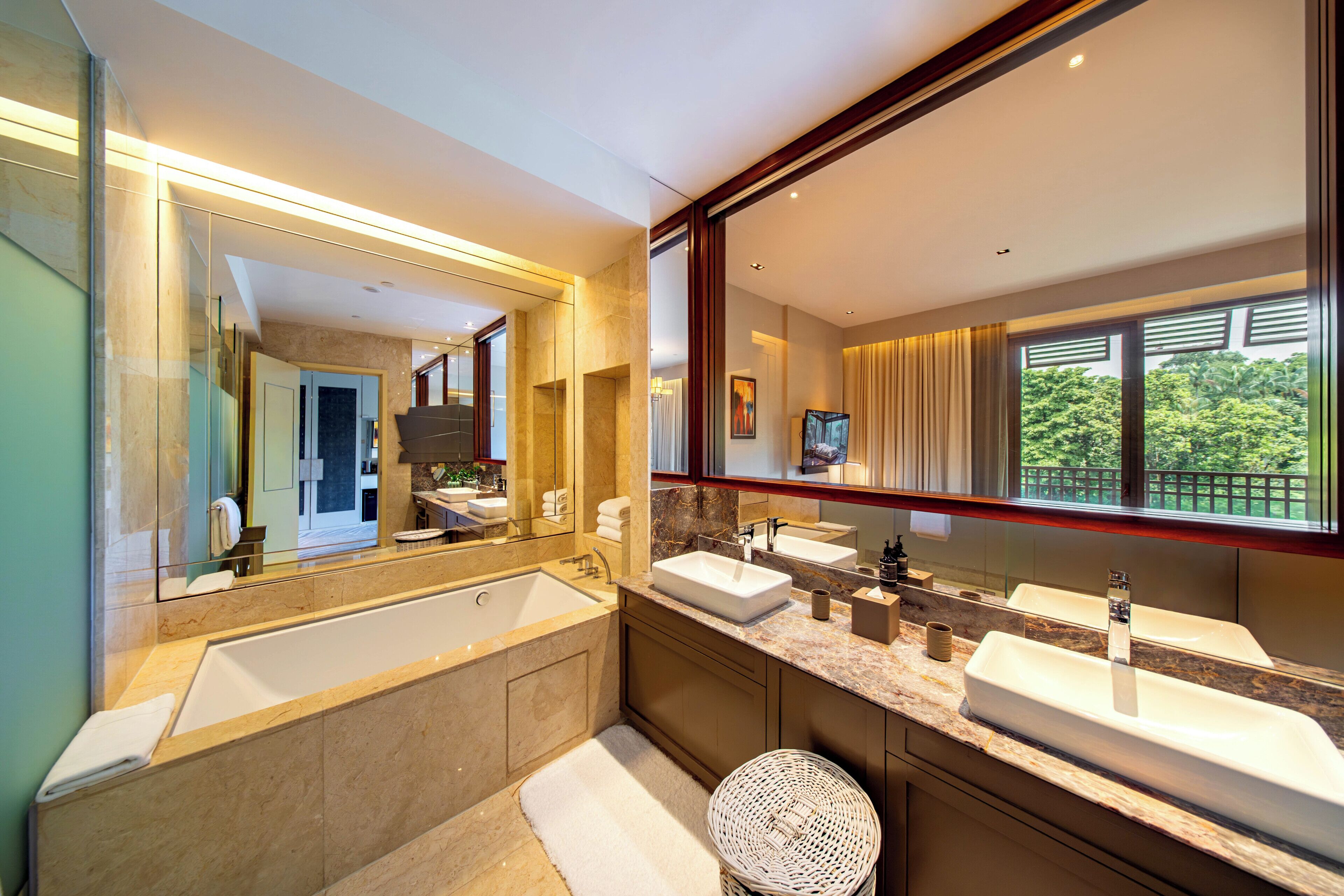 Ein modernes Badezimmer mit zwei Waschbecken, einem großen Spiegel und Blick auf einen Balkon.