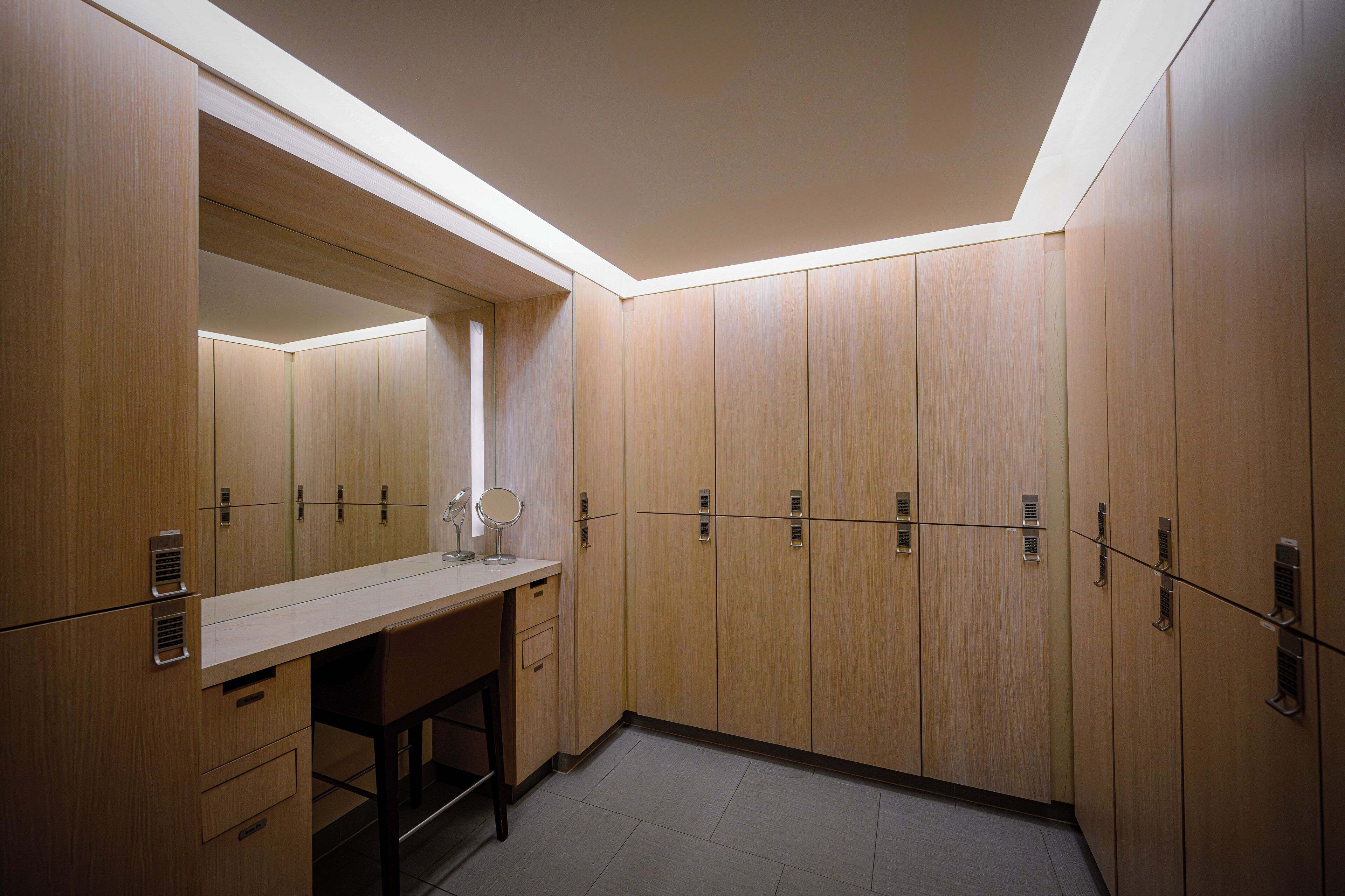 A modern bathroom with wooden cabinets, a mirror, and a sink.