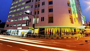 A high-rise hotel with a distinctive triangular top, multiple floors, and a curved facade. - Hotel Continental (George Town)