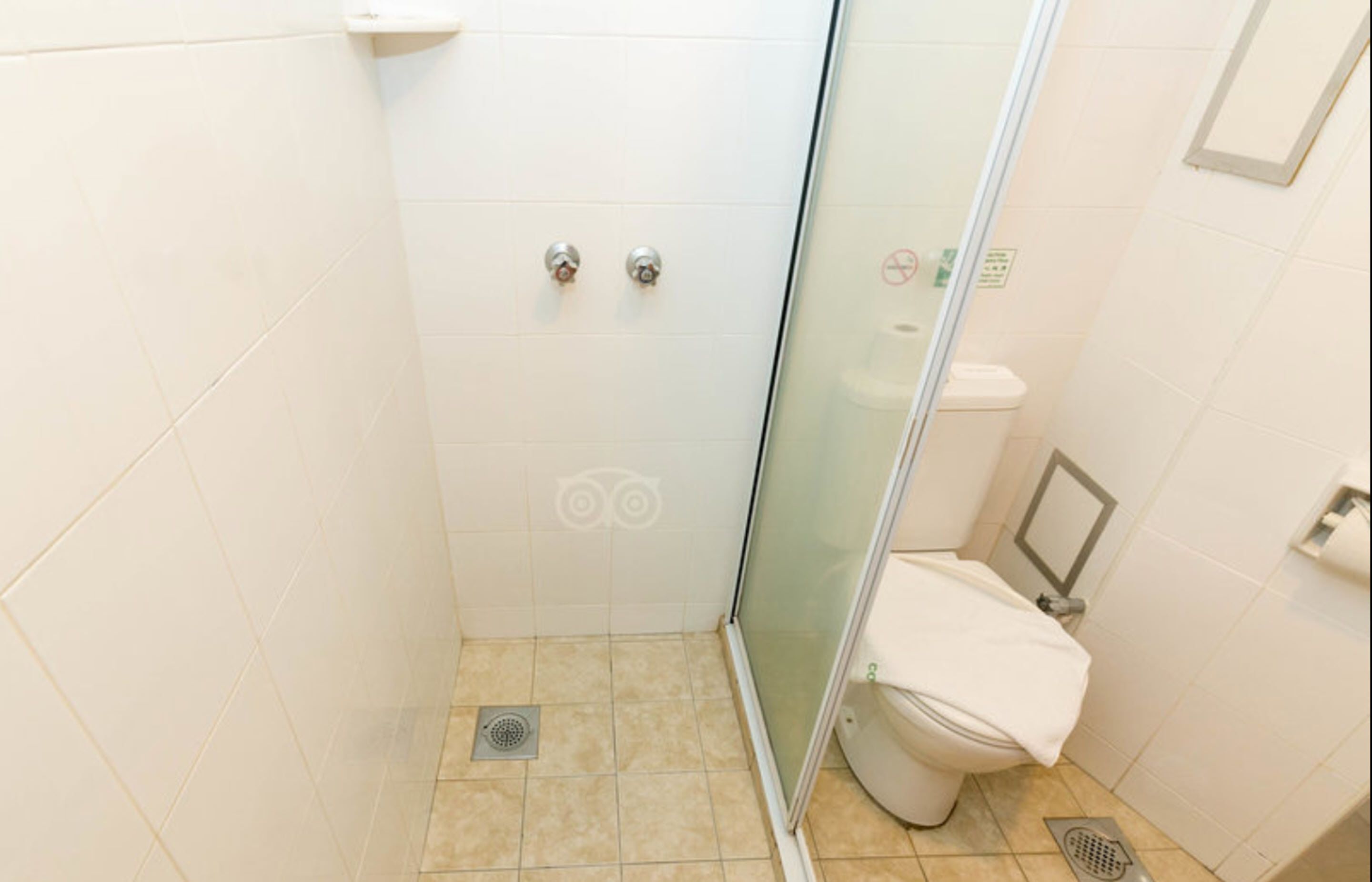 Un baño pequeño y moderno con cabina de ducha de vidrio, inodoro y lavamanos.