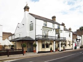 Un edificio blanco con un letrero que dice 'The Flower Pot Hotel'.