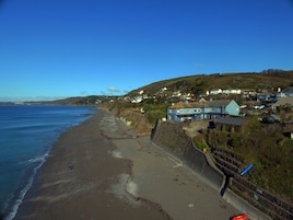 Uma vila costeira com praia, casas e vista para o mar.