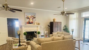 A living room with a fireplace, a sofa, a coffee table, and a lamp. - Old Irish Inn (Denton)
