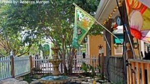 A garden area with a fountain, surrounded by trees and a wooden fence. - Old Irish Inn (Denton)