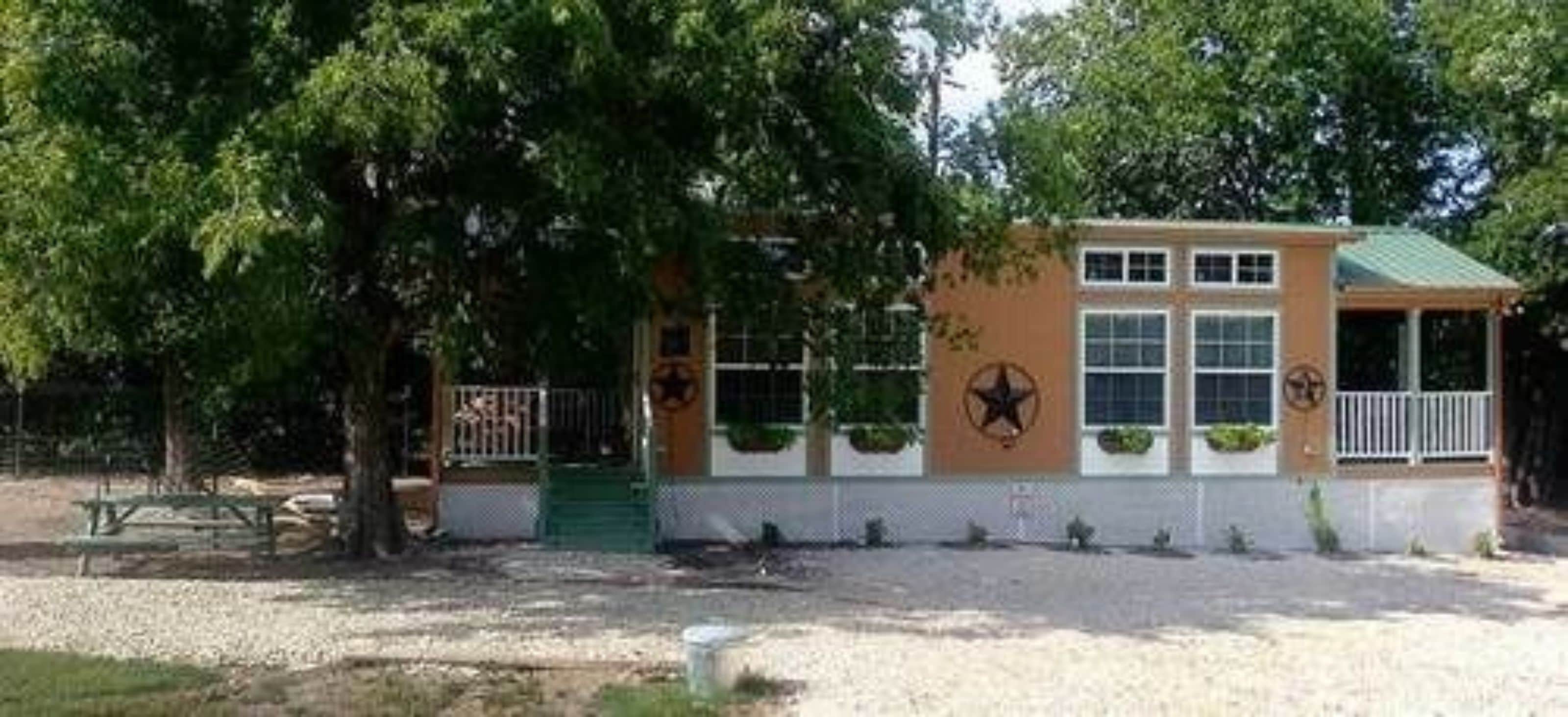 A small building with a green roof, a star emblem, and a fence.