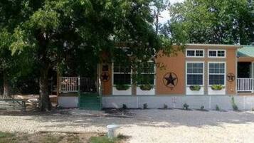 A small building with a green roof, a star emblem, and a fence.