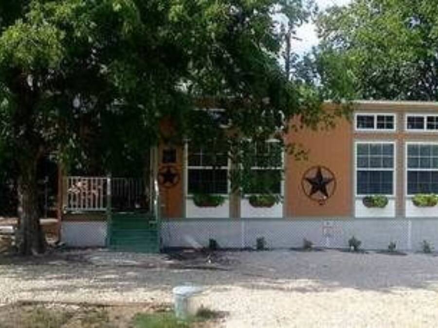 A small building with a green roof, a star emblem, and a fence.