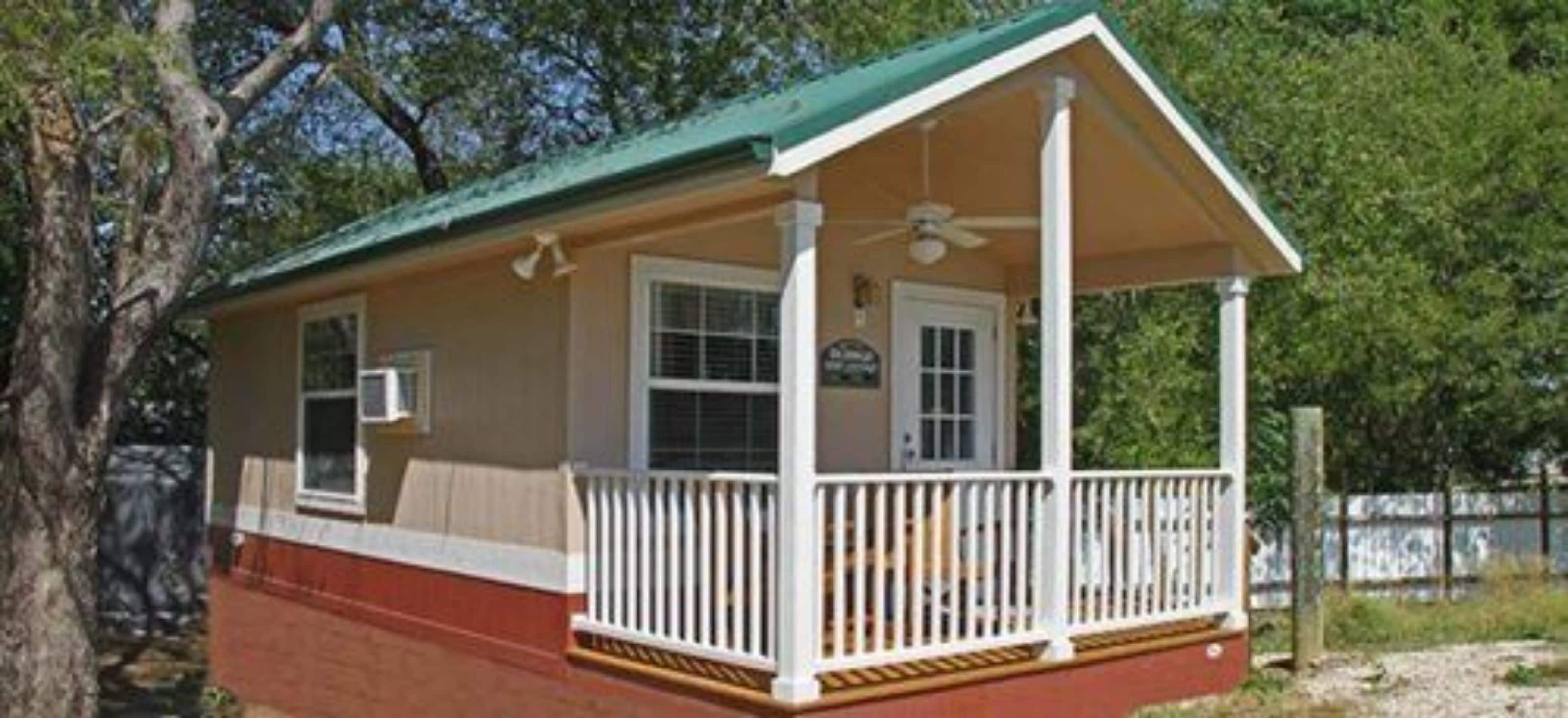 A small, single-story building with a porch, a window, and a door.