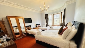 A hotel room with two beds, a large mirror, a television, and a view of the outside through a window. - Abbotsford Guest House (Edinburgh)