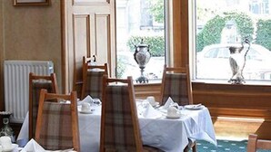 A dining area with tables set for service, chairs, and a window with a view of the street. - Abbotsford Guest House (Edinburgh)