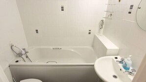 A bathroom with a bathtub, toilet, and sink.