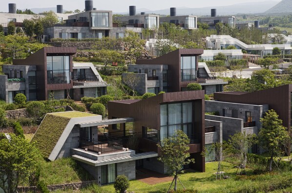 Un complejo residencial moderno con varios edificios que destacan por sus grandes ventanales, techos planos y algunos con cubiertas ajardinadas.