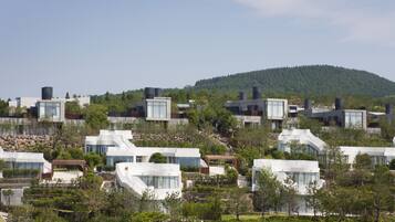 A residential area with modern houses, a hillside, and a clear sky.